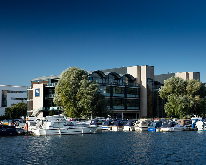 A building with water and boats in the foreground of the picture